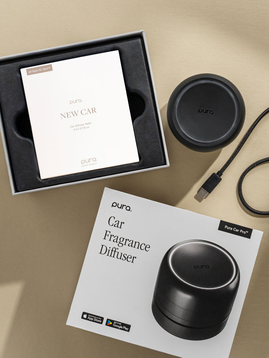 Pura Car Pro diffuser, New Car car fragrance, and packaging on a beige background